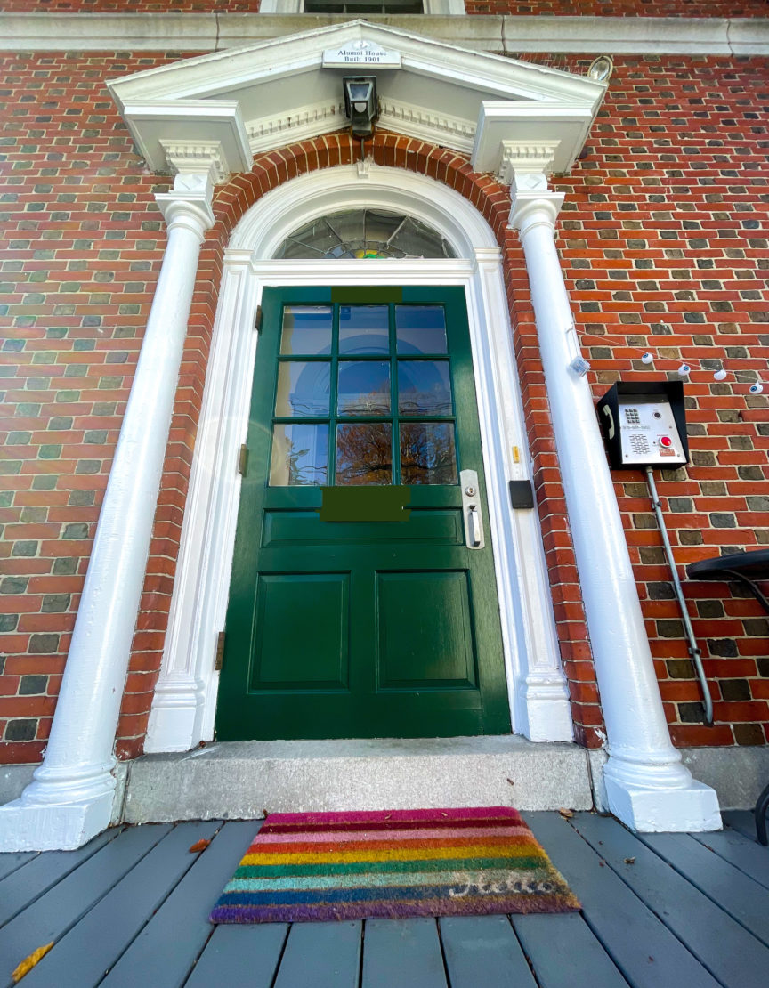 photo of green door of Alumni House & rainbow welcome mat