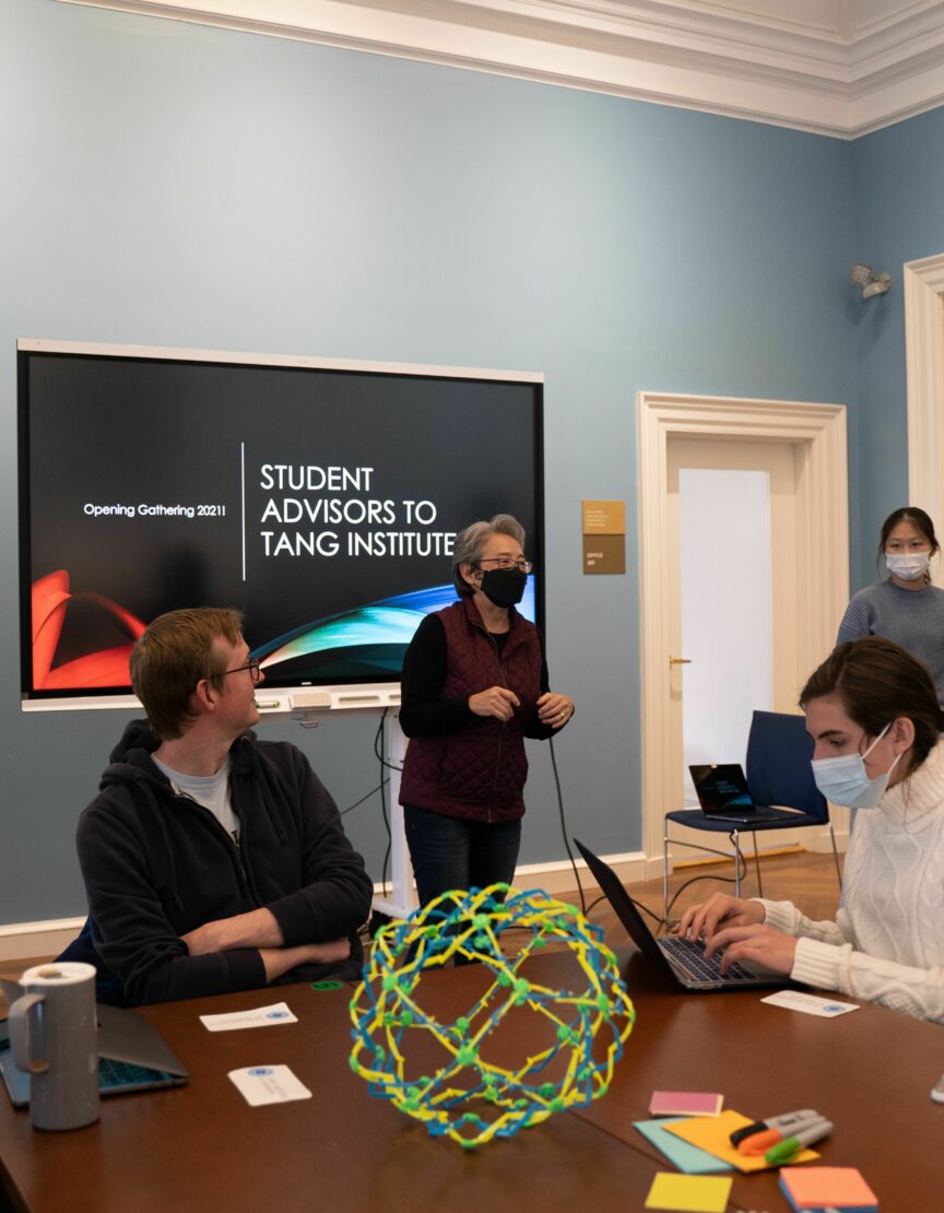 Corrie Martin stands in front of a screen and talks to a group of faculty and students